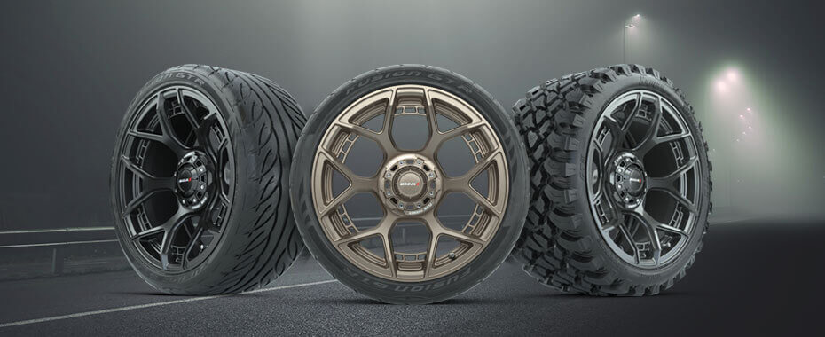 Three tire and wheel combos in a street at night